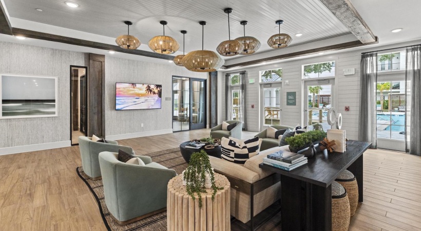 a clubroom with a couch, tables and chairs