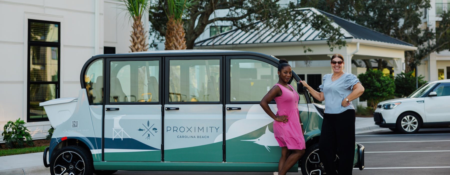 two women standing next to a van